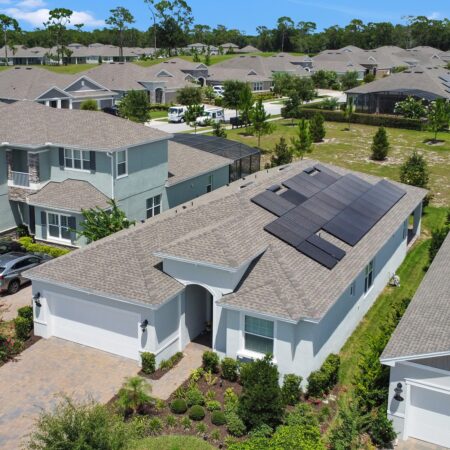 Drone angled view of a residential home in Deland, FL with Solar Panels installed on the roof.