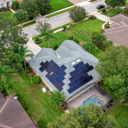 aerial view of a residential home in deltona with solar panels on the roof