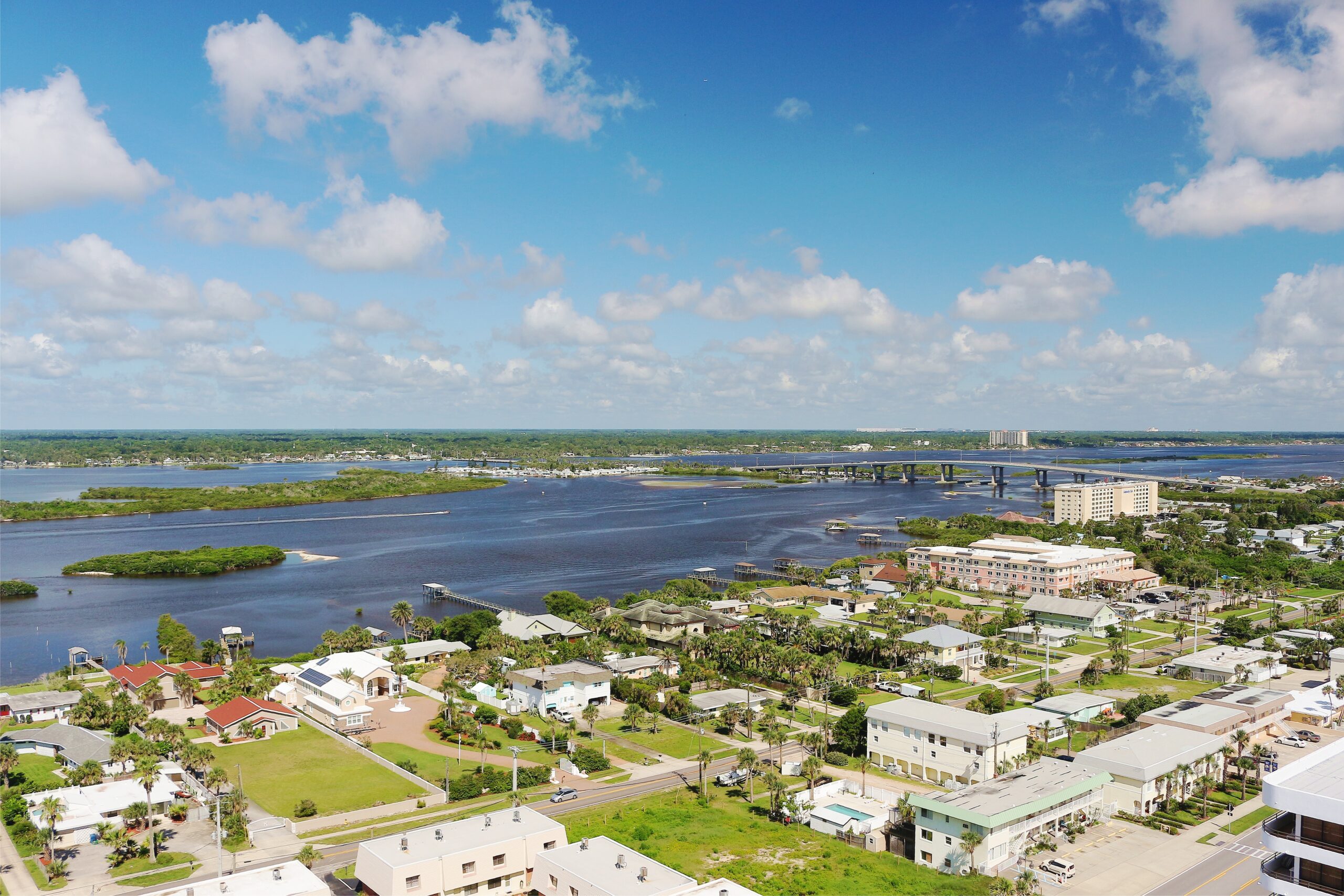 aerial view of the Halifax River and the Port Orange, Florida bridge and homes with Port Orange solar installation.